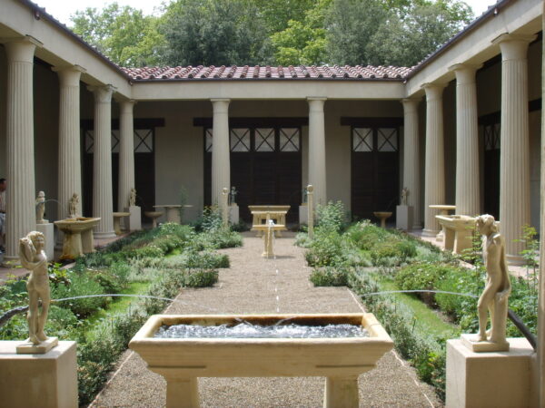 An enclosed courtyard area, with a high columned veranda on all sides - adjacent to these columns are a large number of fountains and statues - within this courtyard there is a broad cross-shaped pathway with formal planting in each quarter