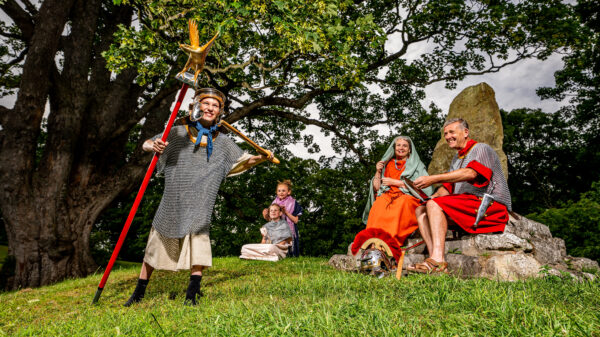 A colour photo showing Roman re-enactment by a small group of adults and children, all wearing Roman clothing