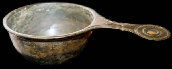 A copper alloy pan against a black background