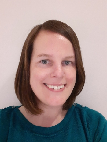 Laura Yeoman, a white woman with brown bobbed hair smiling in a portrait.