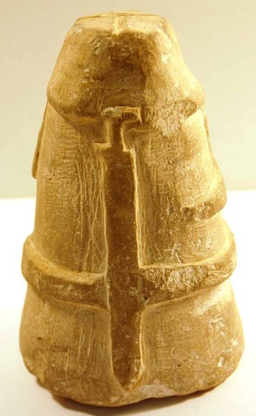 A chalk figurine of an Iron Age warrior wearing a hooded cloak and a belt with a sword from the back.