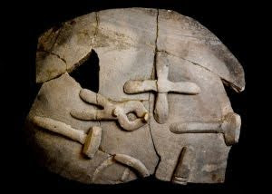 A smith pot made nearby in Norton. The pot is partially fragmented and has two hammers, tongs and two other metal working tools.