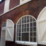 A window with white shutters on a brick building