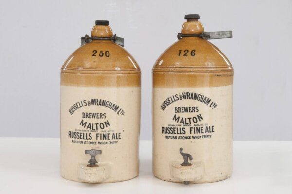 Two beige stoneware ale jars from Russells and Wrangham.