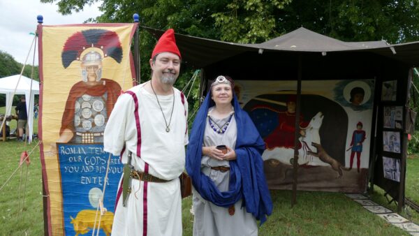 Man and Woman dressed as Romans stand in front of temple